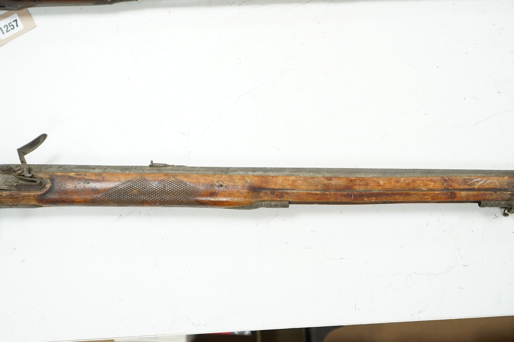 A 32 bore Continental flintlock rifle, unsigned lock, (cock missing) iron mounts and fully stocked, chequered small, sliding patch box cover, (ramrod missing)